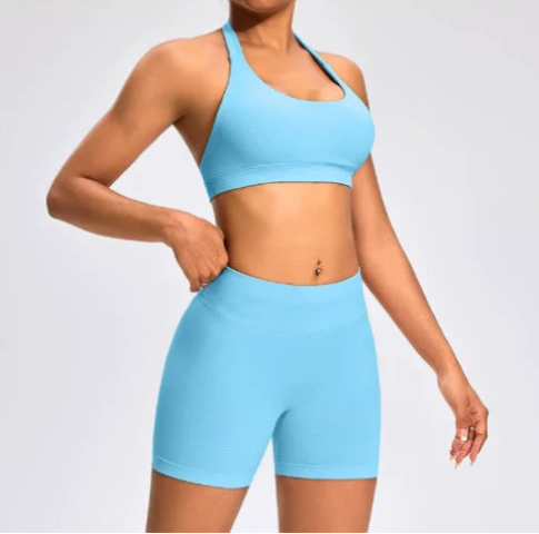 Front view of the Aura Halter Shorts Set in ice blue, featuring a backless halter sports bra and high-waisted seamless activewear shorts.