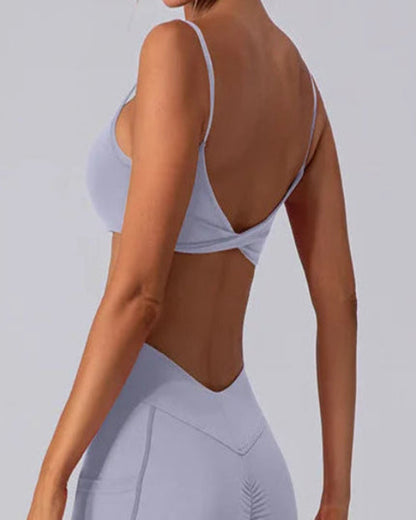 Person wearing a light gray sports bra and leggings set on a plain background