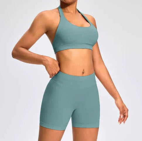 Front view of the Aura Halter Shorts Set in sage green, featuring a backless halter sports bra and high-waisted seamless training shorts.