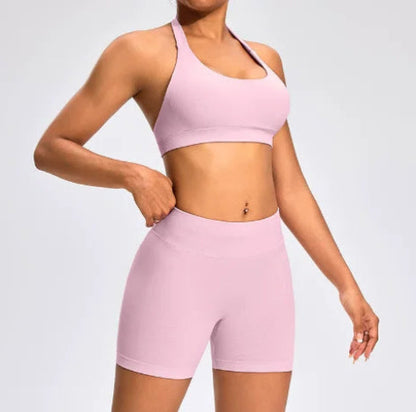 Front view of the Aura Halter Shorts Set in baby pink, featuring a backless halter sports bra and high-waisted seamless activewear shorts.