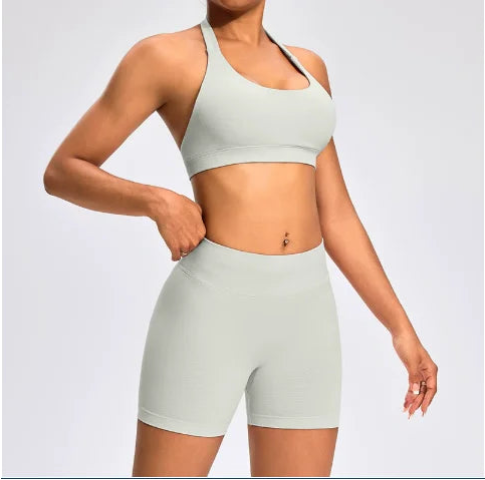 Front view of the Aura Halter Shorts Set in feather beige, featuring a backless halter sports bra and high-waisted seamless activewear shorts.