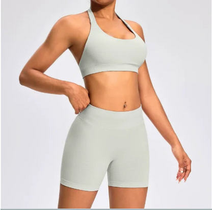 Front view of the Aura Halter Shorts Set in feather beige, featuring a backless halter sports bra and high-waisted seamless activewear shorts.